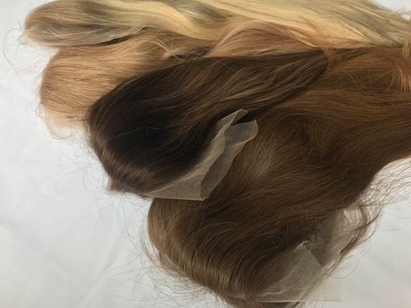 Testing Human Hair Wig Quality A professional inspecting the quality of a human hair wig by checking its density and length.