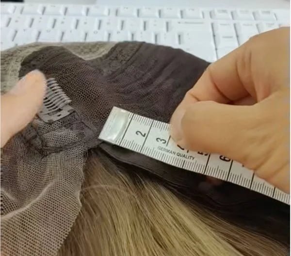 A quality control inspector checking a finished human hair wig
